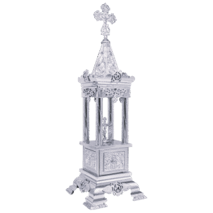 Intricately designed silver religious relic or icon stand with ornate details and a cross on top, used for sacred church ceremonies and displaying holy icons or relics.