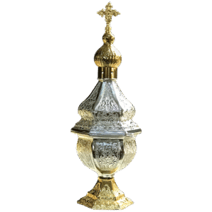Ornate ecclesiastical vessel with gold and silver accents, used in religious ceremonies, featuring intricate engravings and a cross finial at the top.